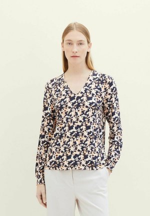 Langarmblouse met V-hals in donker marineblauw, met een bloemenpatroon in perzik en wit. Soepele stof met lichte stretch en geplooide manchetten.