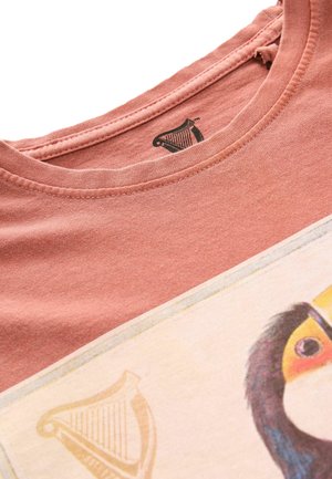 Rosafärgad bomull t-shirt med rund hals, med en tryckt design av en tukan och en harp-logotyp på etiketten.