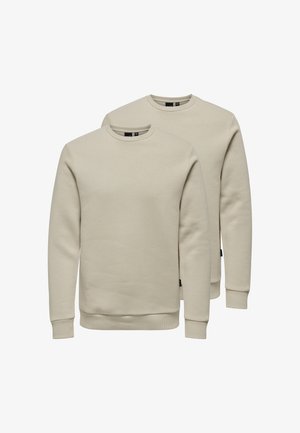 Two beige crewneck sweatshirts displayed front-facing with long sleeves and ribbed cuffs and hems on a white background.