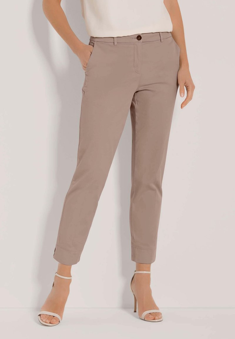 Beige op maat gemaakte broeken met vo pockets, een knoopsluiting en taps toelopende pijpen, voorzien van een gladde stoftextuur en opgerolde manchetten.