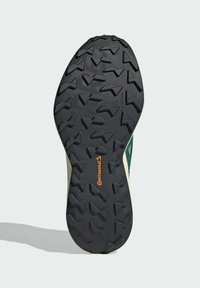 Suola di scarpa in gomma nera con motivo di battistrada multisdirezionale, con logo Continental. Il lato presenta accenti verdi e crema.