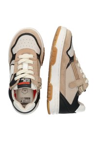Baskets beige et noires avec un mélange de matériaux en suède et en maille, fermeture à lacets, zip sur le côté et semelle en caoutchouc texturée. Branding notable à l'intérieur.