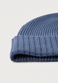 Căciulă tricotată albastră cu textură tip côtelé, prevăzută cu un manșon pliat. Materialul pare moale, cu un finisaj uniform și neted.