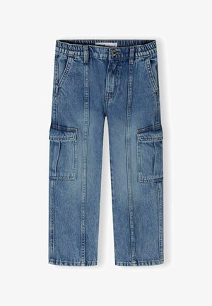 Des pantalons cargo en denim bleu présentent une ceinture élastique, deux poches latérales et deux grandes poches cargo sur les cuisses. Le tissu a une texture délavée.