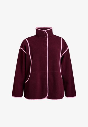 Burgundska flis jakna s visokim ovratnikom, prednjim dugmadi i kontrastnim ružičastim obrubom duž šavova i rukava. Ima bočne džepove.