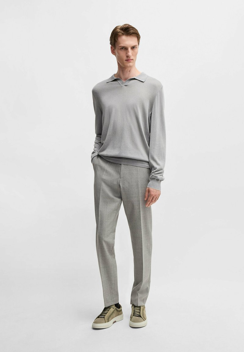 Gray long-sleeve polo shirt with a subtle sheen, paired with light gray tailored trousers and olive green sneakers with a textured surface.