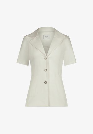 Hellbeige Bluse mit kurzen Ärmeln und einem eingeschnittenen Kragen, drei Knöpfen mit silbernen Akzenten und zwei vorderen Taschen. Strukturierter Stoffdesign.