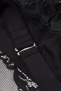 Lingerie noire avec des accents en dentelle florale, bretelles ajustables et une bande élastique texturée. Le design comprend des motifs de dentelle complexes.