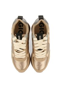 Zapatillas deportivas con un acabado metálico bronce suave, cordones crema, cuello acolchado y acentos texturizados a lo largo de los lados. Logo negro visible en el interior.