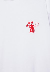 White fabric with a small red embroidered design of a cowboy holding a lasso and three stars above him.