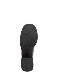 Suela de zapato negra con un patrón de agarre texturizado, tacón rectangular y acabado suave; presenta tres secciones distintas en el diseño de la banda de rodadura.
