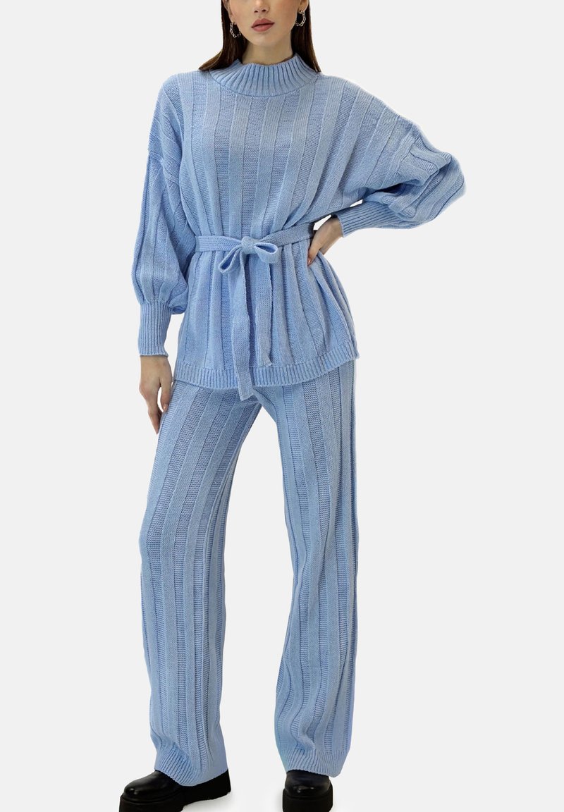 Jasnoniebieski zestaw dzianinowy z żebrowanym wzorem, wysokim kołnierzem, paskiem w talii oraz szerokimi spodniami o teksturowanej tkaninie.