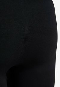 Sorte leggings af glat, strækbart stof med et tekstureret panel og forstærket syning i taljen for holdbarhed.