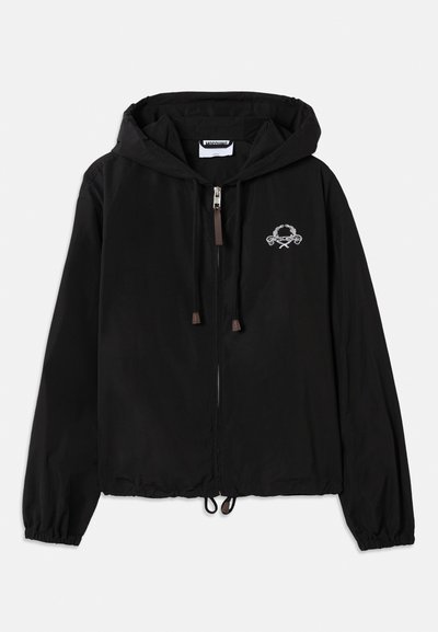 Svart huvjacka i lättviktsmaterial. Har en framzipper, elastiska ärmslut och en logotypapplikation med dekorativa accenter på bröstet.