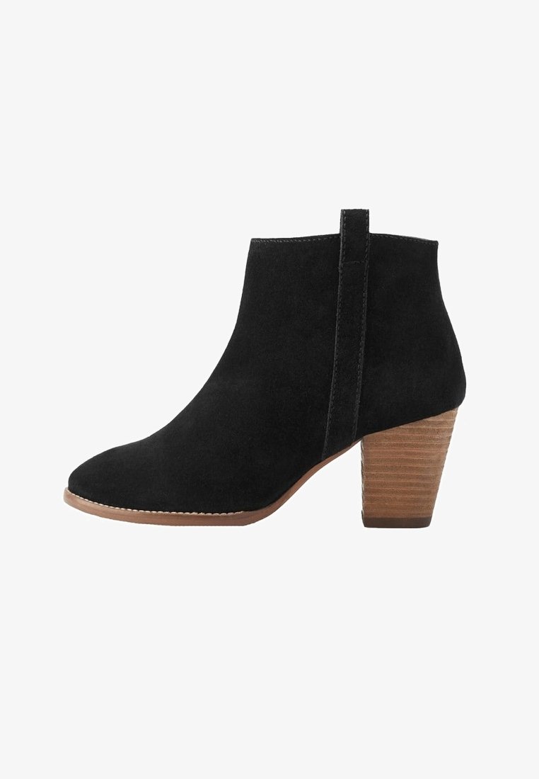 Bottine en daim noir avec talon bloc en bois superposé et languette à l'arrière, présentant un bout arrondi et une couture latérale.