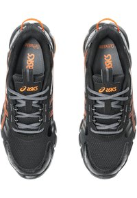 Scarpe sportive nere con lacci grigi e accenti arancioni. Presentano una tomaia testurizzata, un collarino imbottito e una suola in gomma. Logo sulla linguetta.