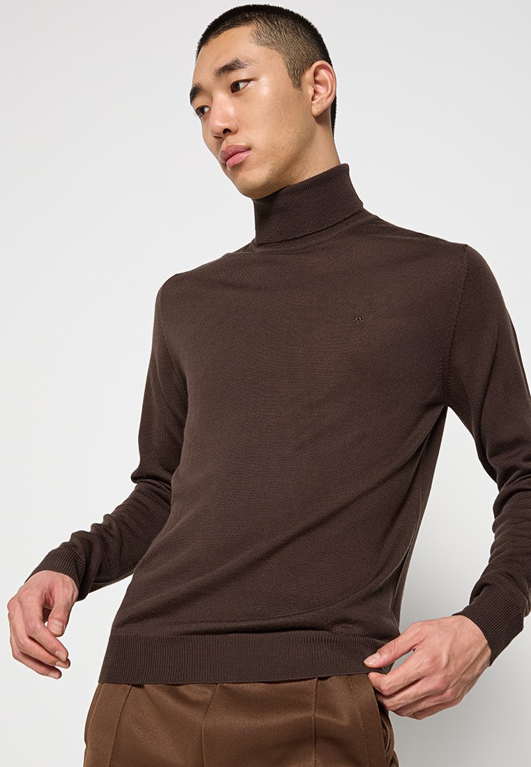 Brązowy sweter z golfem wykonany z gładkiej, delikatnej dzianiny, z prążkowanymi mankietami i dołem, z małym, tłoczonym logo na piersi.
