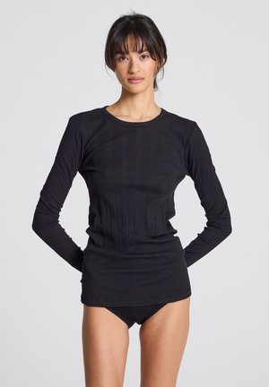 Top nero a maniche lunghe con texture a coste e scollatura rotonda, design aderente, realizzato in tessuto elasticizzato, abbinato a un perizoma nero coordinato.