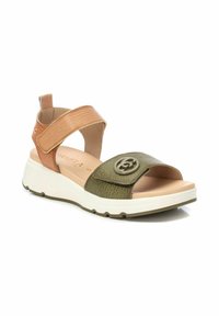 Sandalia de cuero marrón y verde con una correa ancha, parte superior texturizada, acento de logo y una suela blanca acolchada. Correa ajustable en el tobillo.