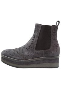 Botín de ante gris con detalles de brogue, paneles elásticos laterales y suela de flatform. Se puede apreciar una textura suave y perforaciones decorativas.