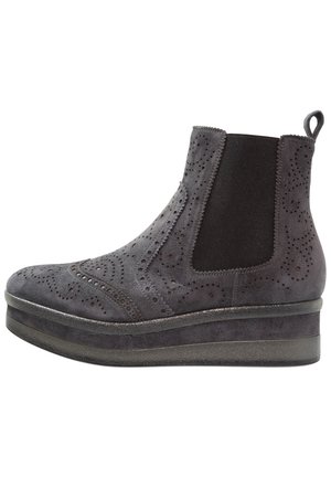 Botín de ante gris con detalles de brogue, paneles elásticos laterales y suela de flatform. Se puede apreciar una textura suave y perforaciones decorativas.