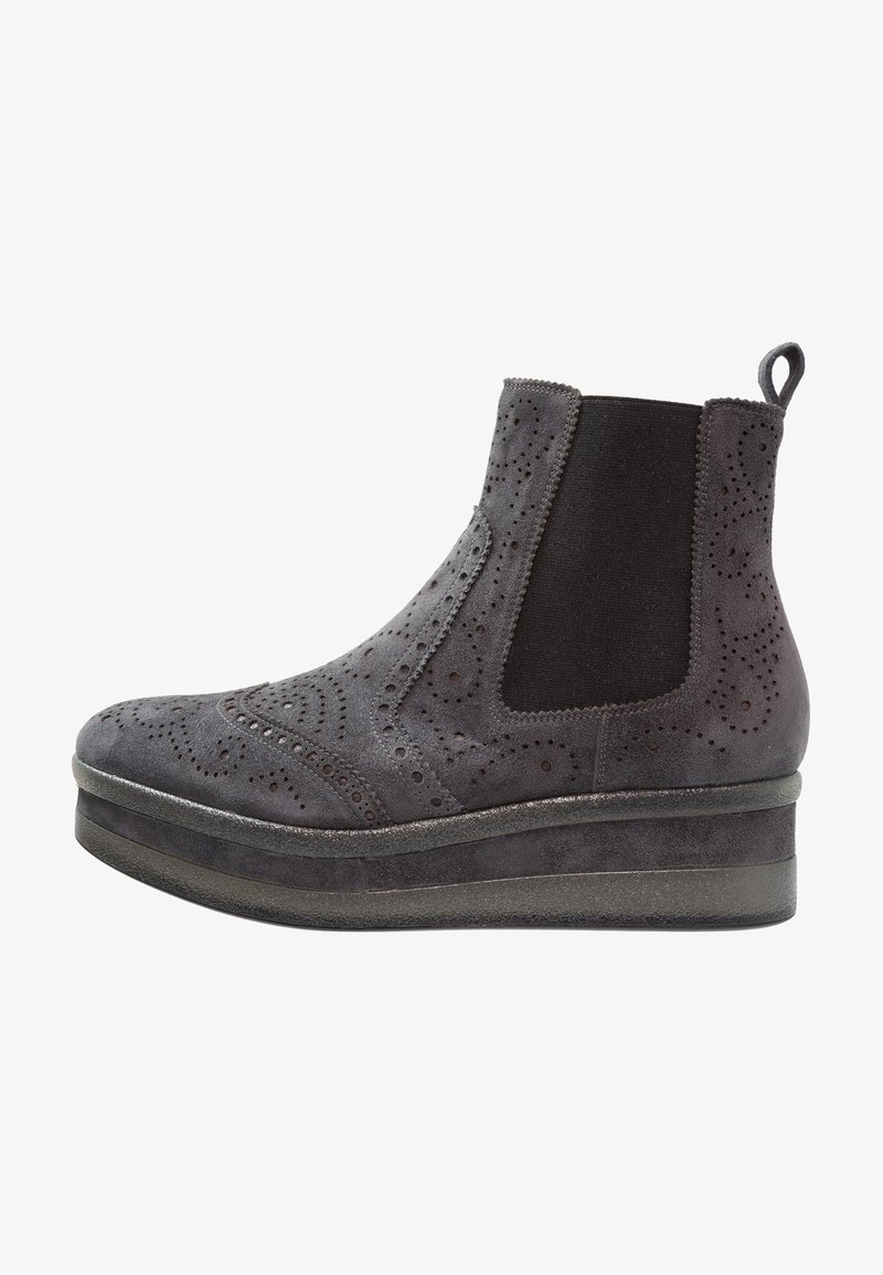 Botín de ante gris con detalles de brogue, paneles elásticos laterales y suela de flatform. Se puede apreciar una textura suave y perforaciones decorativas.