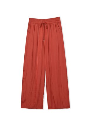 Pantalones de pierna ancha en color óxido, hechos de tela liviana. Cuentan con una cinturilla elástica con cordón y bolsillos laterales.