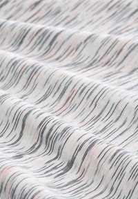 Tissu avec une base blanche ornée de lignes ondulées noires et roses. Le tissu a une texture douce et une finition lisse, affichant des motifs subtils.