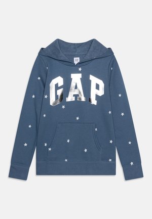 Niebieska bluza z kapturem z srebrnym napisem „GAP” i białymi wzorami gwiazdek rozmieszczonymi na rękawach i przedniej kieszeni.