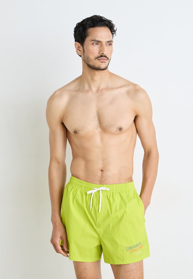 Bañador de color verde lima brillante, hecho de una tela ligera, que cuenta con una cinturilla elástica con cordón y sutiles detalles bordados.