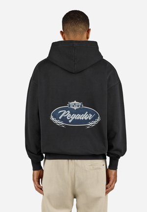 Black hooded sweatshirt featuring a large oval graphic on the back with the text "Pegador" in white, outlined in blue, and checkered accents.
