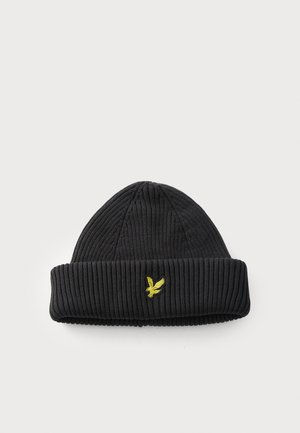 Gorro negro de punto acanalado con puño doblado y pequeño logo de pájaro bordado en amarillo en el centro frontal.