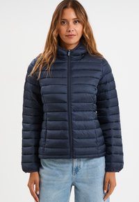 Chaqueta acolchada de color navy con líneas horizontales, cuello alto y cierre frontal. Textura suave y lisa, y diseño ajustado para calidez y comodidad.