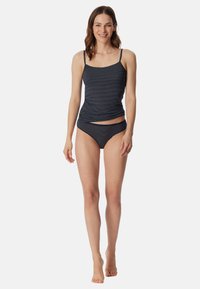Top tankini a righe navy con spalline regolabili; design arricciato. Il bikini coordinato presenta un vita bassa e un tessuto morbido.