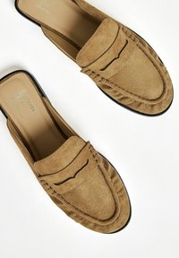 Barna velúr slip-on loaferek lekerekített orral, díszített varrással és texturált talpbetéttel. A talp lapos és fekete.