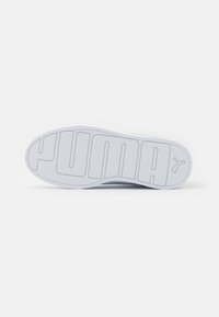 Semelle en caoutchouc blanc de chaussure avec grand logo "PUMA" en relief et surface texturée pour l'adhérence. Bords arrondis avec un design lisse.