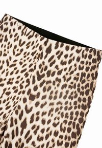 Leopardų rašto leggingai, pagaminti iš lygios medžiagos, turinčios smėlio ir rudos spalvų derinį, su juoda liemene.