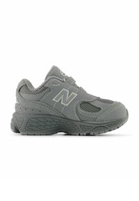 Baskets de sport New Balance grises avec panneaux en mesh, logo cousu sur le côté et semelle épaisse texturée, vues de côté extérieur.
