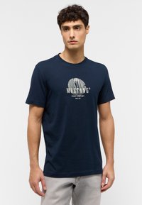 Kék pamut póló kerek nyakkal, középen világossz�ürke felirattal: "MUSTANG Jeans Company".