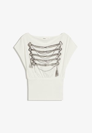Top alb cu mâneci scurte și decolteu barcă, cu model imprimat de lanțuri metalice și ciucuri pe piept, și talie ajustată în partea de jos.