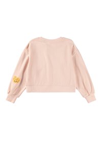 Svetloružový cropped sveter s dlhými rukávmi, so žebrovanými manžetami a malou žltou nášivkou s usmievavou tvárou na ľavom rukáve.