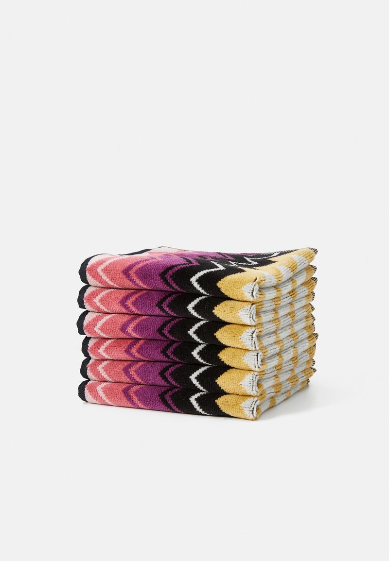 Stack of patterned towels featuring a zigzag design in pink, purple, yellow, and black with contrasting white accents and textured fabric.