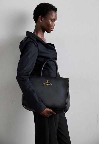 Sort læderhåndtaske med detalje i guld, struktureret design, dobbelthåndtag, glat tekstur og metalindsatser ved bunden.