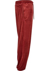 Röda velour joggers med elastisk midja, justerbar dragsko, sidofickor och snäva benslut. Slät textur och mjukt utseende.