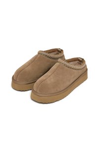 Scarpe slip-on in suede marrone con interno morbido, caratterizzate da un'area colletto testurizzata e lavorata a intreccio e suola in gomma spessa.