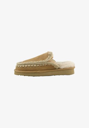 Pantofole in camoscio color cuoio chiaro con interno in lana crema, rifinitura intrecciata lungo il bordo e suola piatta in gomma con superficie testurizzata.