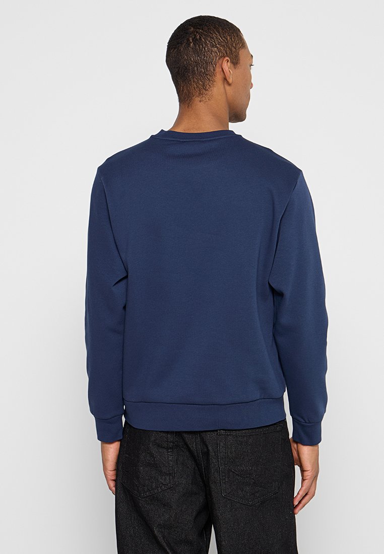 Marineblauwe sweatshirt met een ronde hals, ribgebreide manchetten en zoom, gemaakt van zachte, gestructureerde stof. Heeft een schone achterkant.