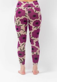 Blumenleggings mit einem beigen Hintergrund, großen lila Blüten und grünen Blättern. Der Stoff ist glatt und enganliegend, mit einem elastischen Bund.