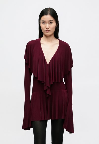Robe portefeuille bordeaux avec volants superposés, décolleté en V profond, manches longues évasées et taille cintrée, fabriquée en tissu doux et fluide.