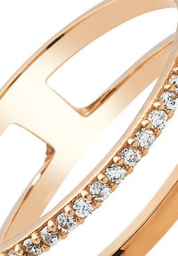 Bague en or rose avec un design ouvert présentant une bande droite et une rangée de petites pierres rondes et claires sur un côté. Finition lisse.